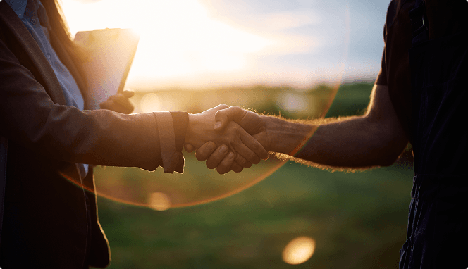 Handshake at sunset in a field — supply chain partnerstip