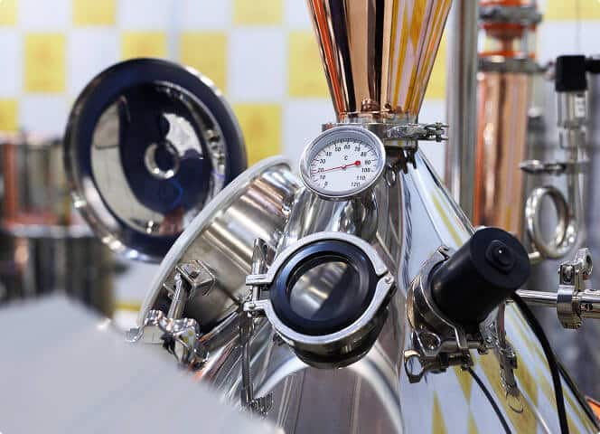 Copper-and-steel distillation column with temperature gauge inside the Alquora distillery