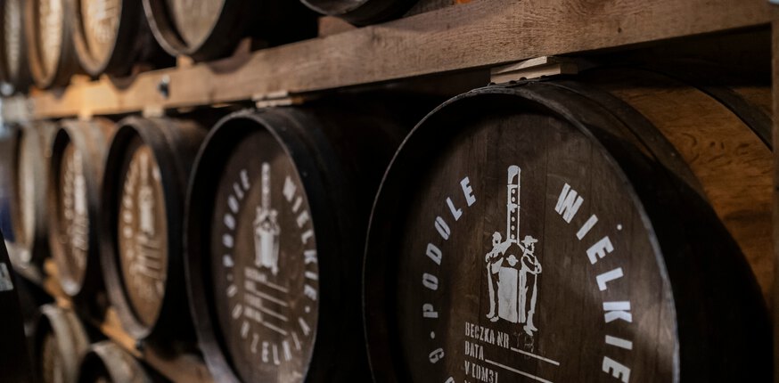 Oak barrels bearing the Podole Wielkie emblem in the distillery warehouse
