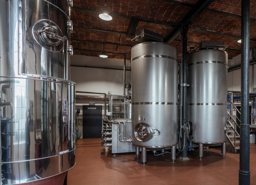 Alquora distillery hall with steel tanks under a brick ceiling